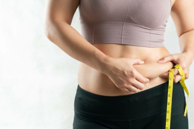 concept image of woman checking causes of belly fat